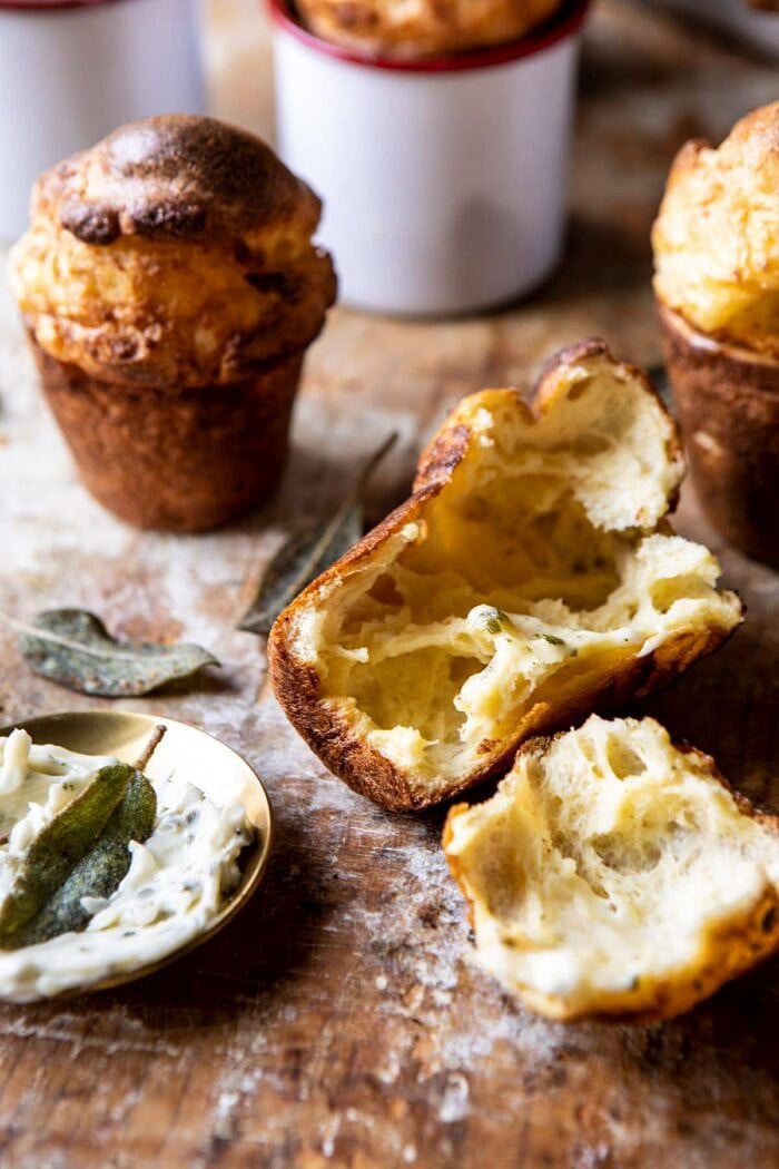 Parmesan Popovers with Crispy Sage Garlic Butter | halfbakedharvest.com #popovers #bread #easyrecipes front on close up photo of Parmesan Popovers with Crispy Sage Garlic Butter broken in half to show the airy inside of the popover