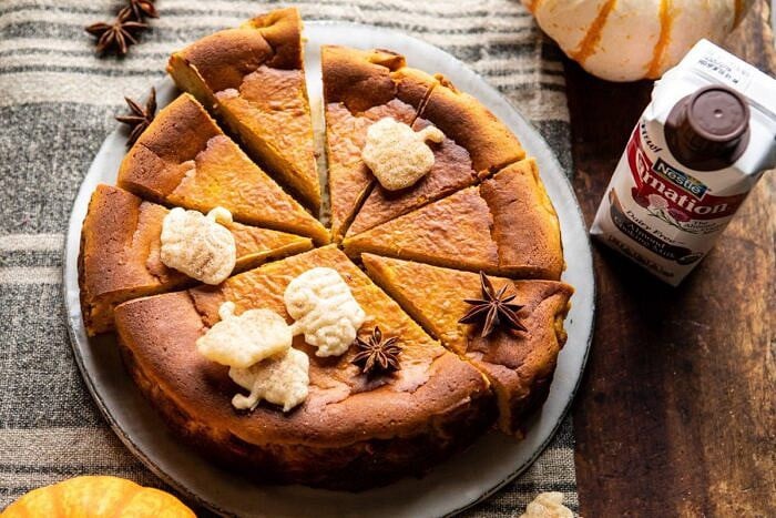 horizontal photo of Burnt Basque Pumpkin Spice Cheesecake with almond milk in photo next to cheesecake