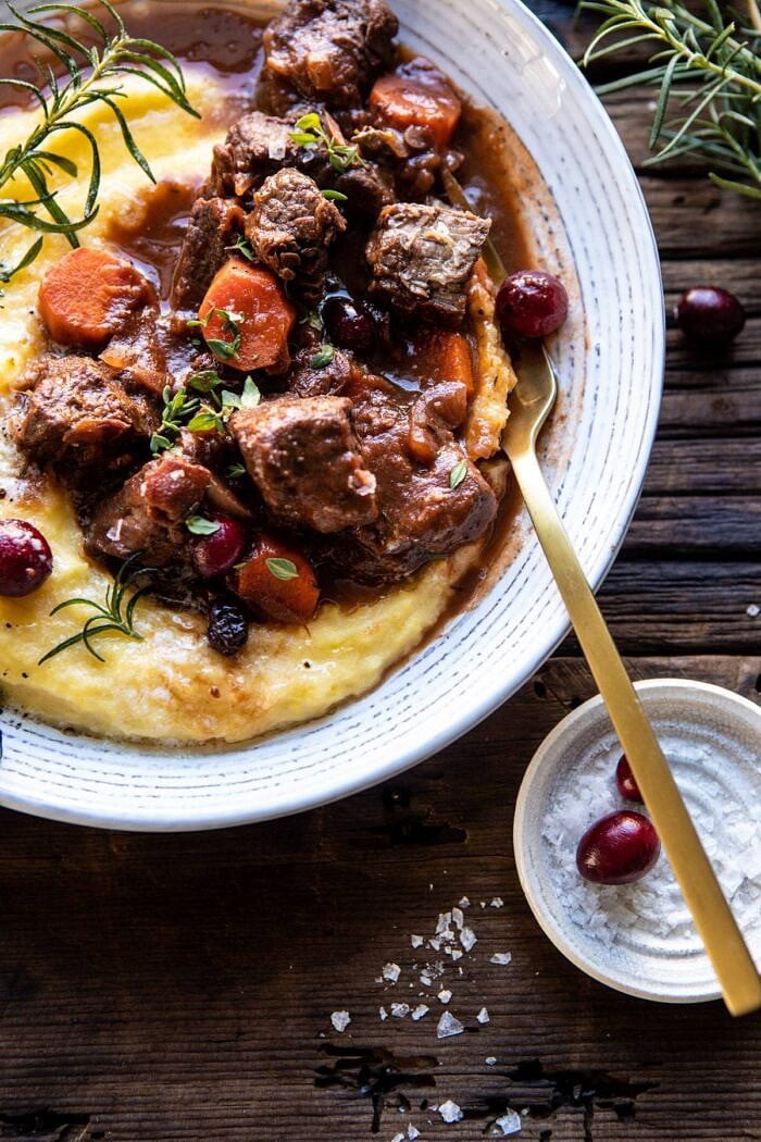 Cranberry Cider Braised Beef Stew with Rosemary Polenta | halfbakedharvest.com #slowcooker #instantpot #beef #polenta overhead photo of Cranberry Cider Braised Beef Stew with Rosemary Polenta with fork in bowl