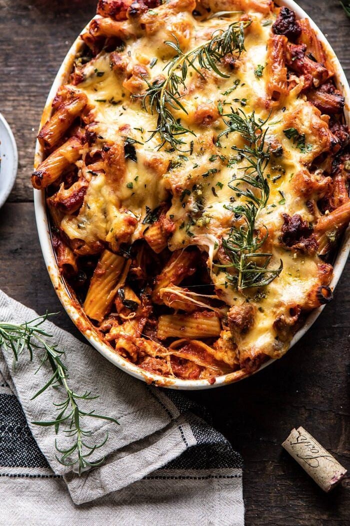 overhead close up photo of One Pot Spicy Pesto Cheese Baked Rigatoni with serving of pasta removed from baking dish