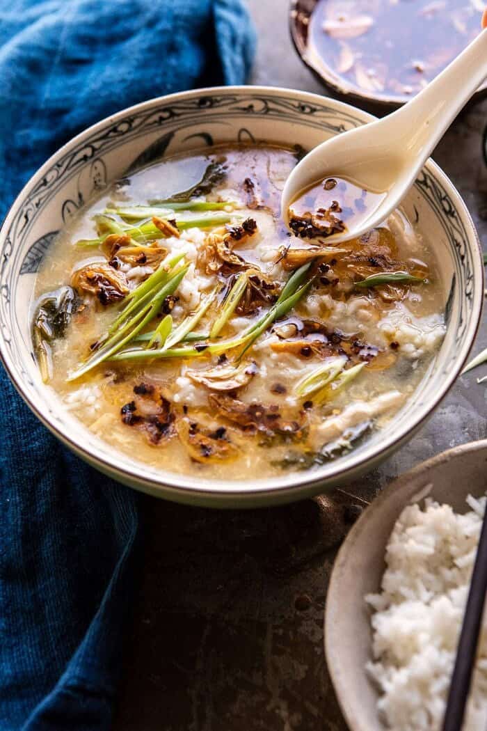 30 Minute Chinese Egg Drop Chicken Rice Soup with Garlicky Chile Oil | halfbakedharvest.com #chinese #easyrecipes #30minutedinner #soup side angled photo of 30 Minute Chinese Egg Drop Chicken Rice Soup with Garlicky Chile Oil being spooned over the soup