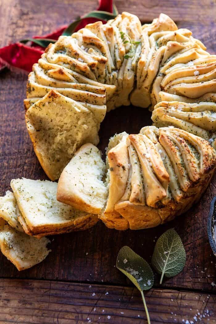Pull-Apart Garlic Butter Bread Wreath | halfbakedharvest.com #garlicbread #Christmas side angled photo of Pull-Apart Garlic Butter Bread Wreath with a few slices pulled away from bread