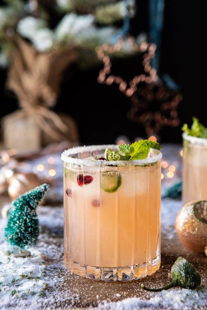 The Spicy Sweet Grinch Cocktail | halfbakedharvest.com #thegrinch #christmasdrinksaturday #vodka side angle photo of The Spicy Sweet Grinch Cocktail with christmas tree in the background