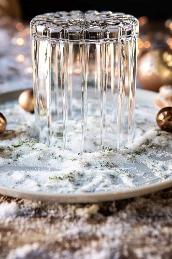 The Spicy Sweet Grinch Cocktail | halfbakedharvest.com #thegrinch #christmasdrinksaturday #vodka rimming cocktail glass in mint sugar