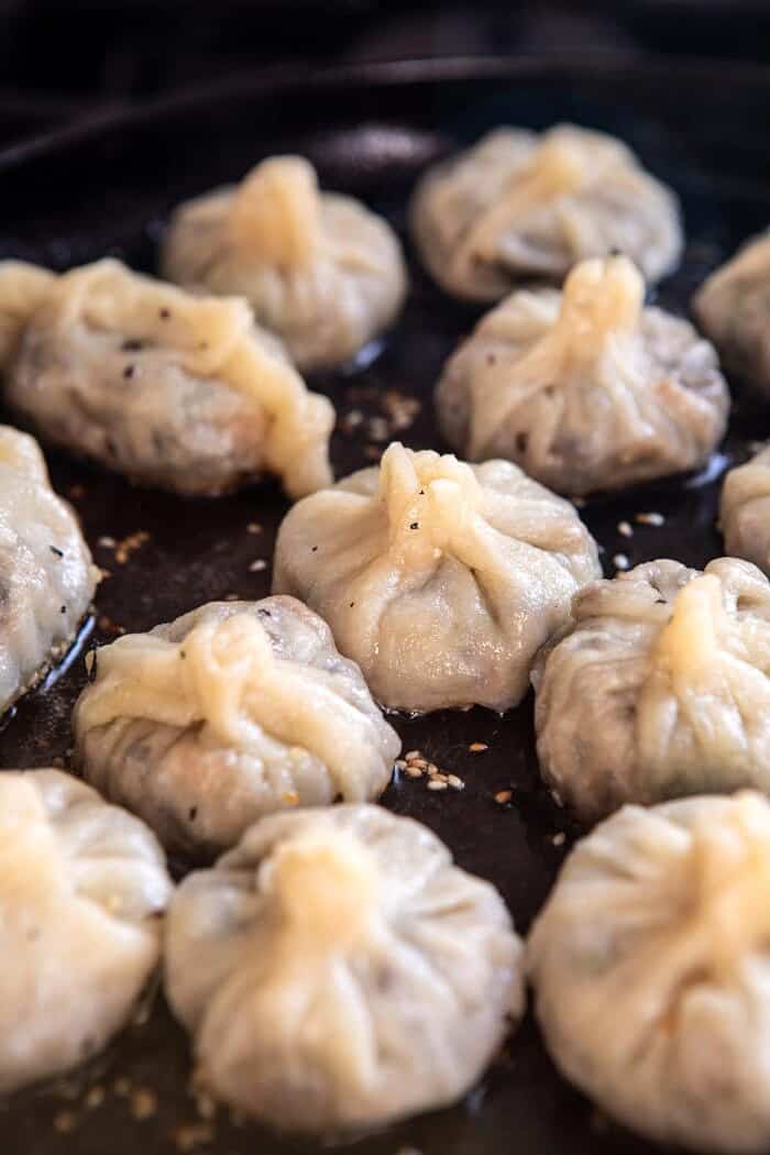 Chinese Mushroom Dumplings cooking in skillet 