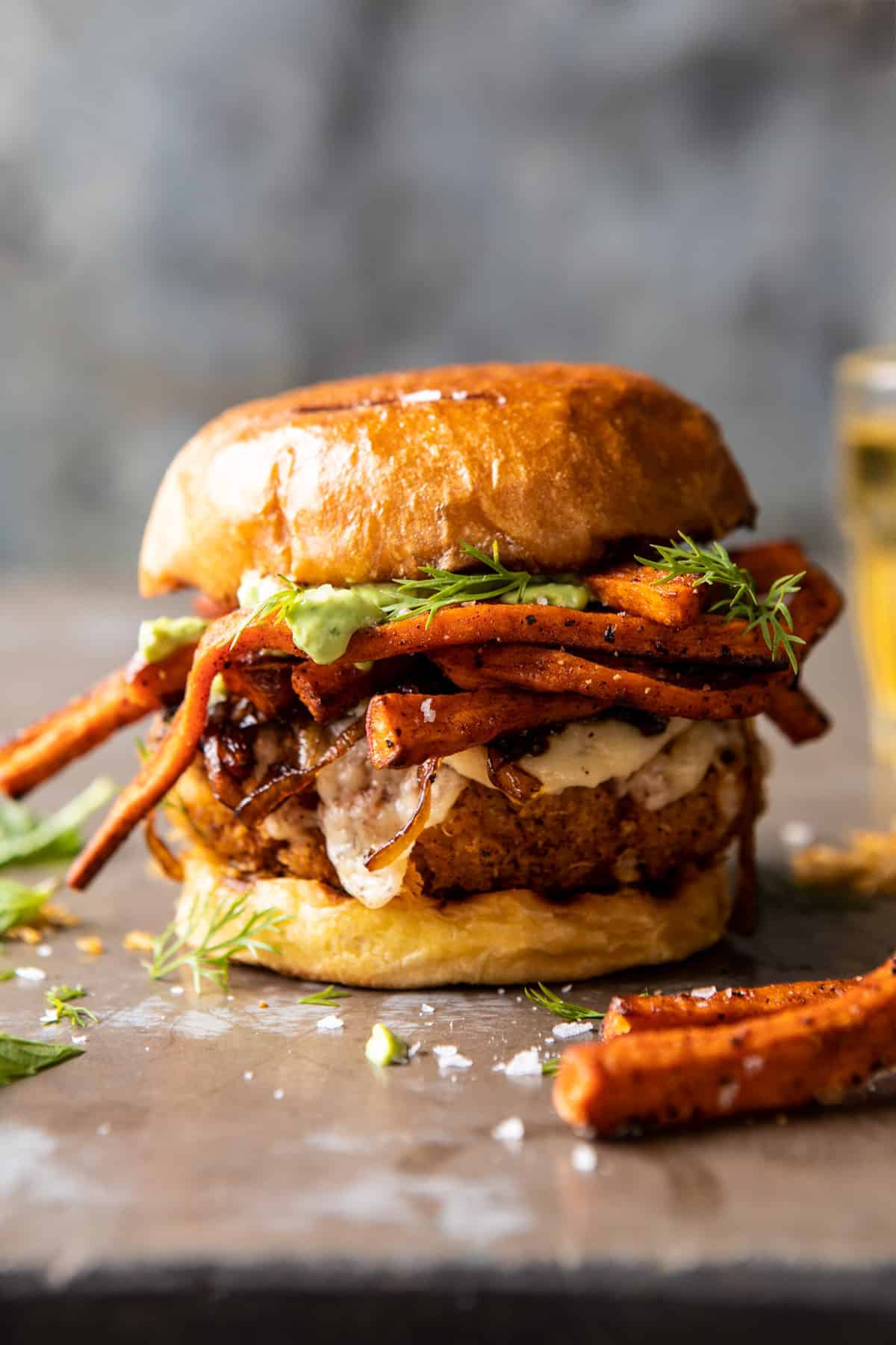 Crispy Quinoa Burgers Topped with Sweet Potato Fries and Beer Caramelized Onions | halfbakedharvest.com #quinoaburger