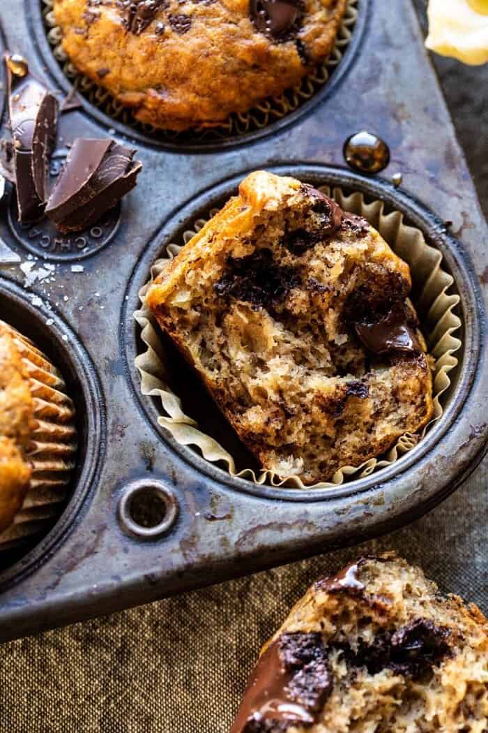 One Bowl Chocolate Chunk Chai Banana Muffins | halfbakedharvest.com #healthy #bananabread #muffin side angled close up of One Bowl Chocolate Chunk Chai Banana Muffins bitten in half