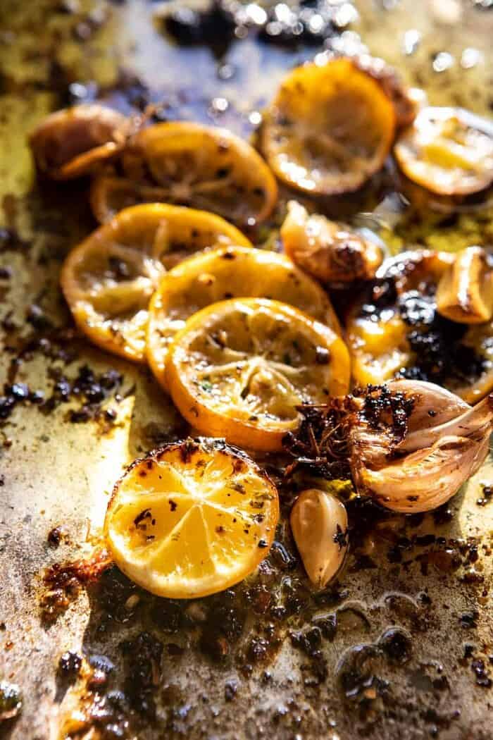 Roasted Garlic Butter Chicken with Lemon Olive Dressing | halfbakedharvest.com #chicken #sheetpan #easyrecipes lemons on sheet pan after roasting