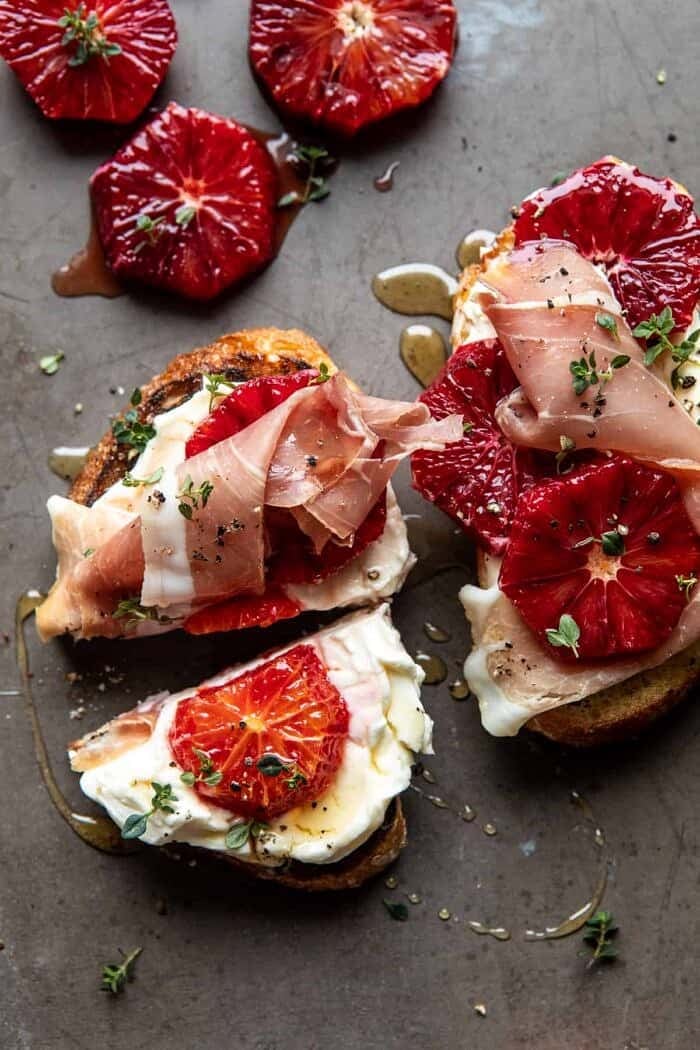 overhead photo of Simplest Whipped Ricotta Toast with Lemon Thyme Honey with 1 piece of toast cut in half