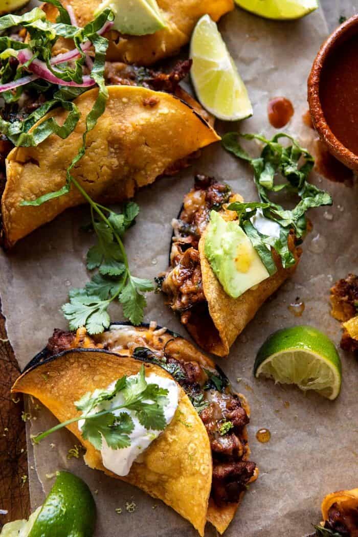 Crispy Chipotle Chicken Tacos with Cilantro Lime Ranch | halfbakedharvest.com overhead photo of Crispy Chipotle Chicken Tacos with bite taken out of taco