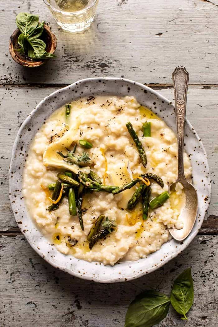 No Stir Brie Risotto with Lemon Butter Asparagus | halfbakedharvest.com overhead photo of No Stir Brie Risotto with Lemon Butter Asparagus and spoon placed in the bowl with risotto