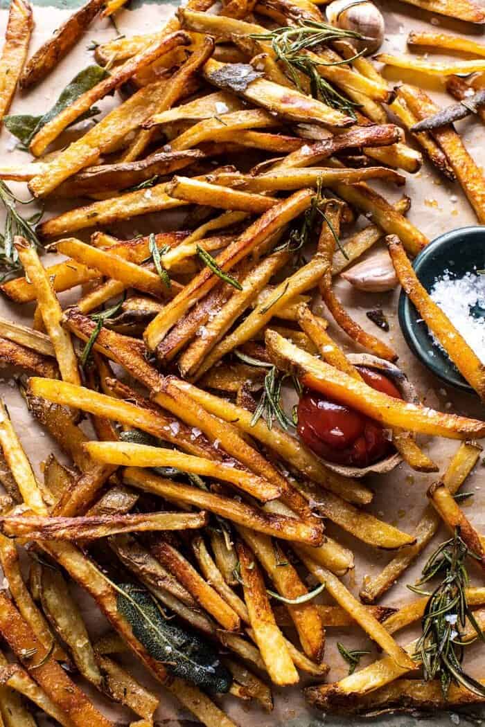Oven Baked Tuscan Fries | halfbakedharvest.com overhead photo of Oven Baked Tuscan Fries with a couple fries sitting in ketchup