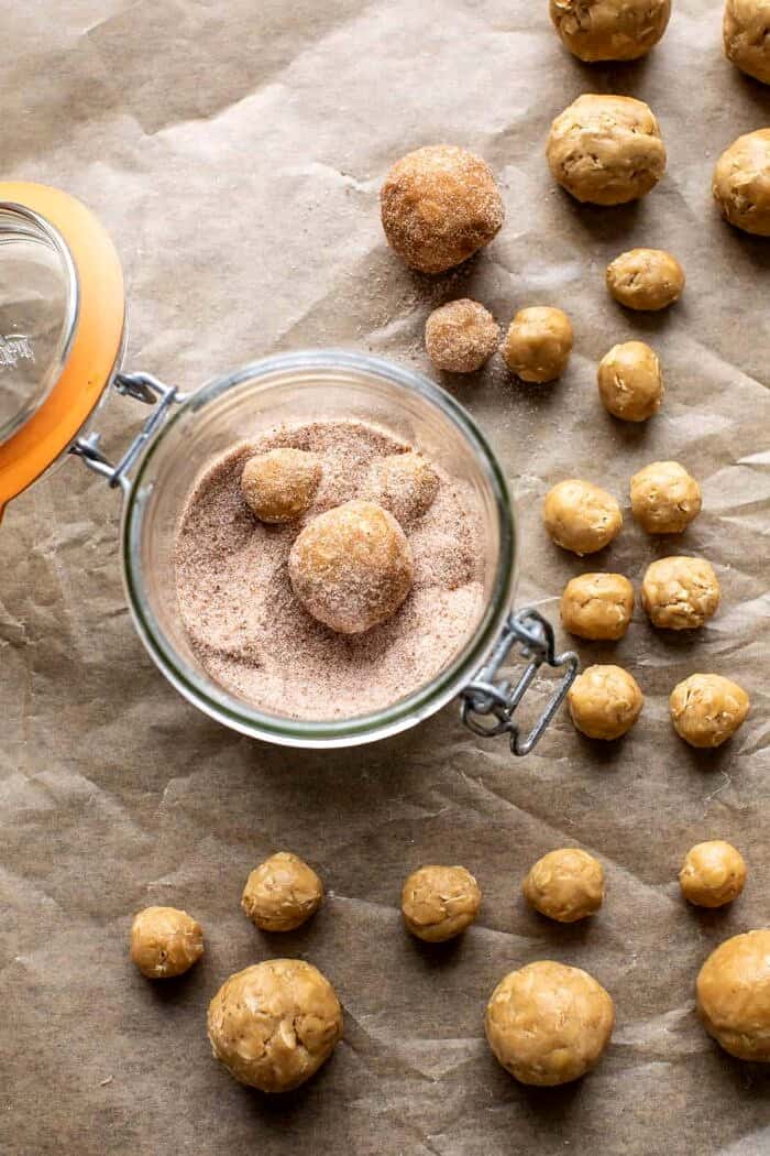Sweet and Salty Teddy Bear Snickerdoodles | halfbakedharvest.com prep photo of rolling the dough balls in cinnamon sugar