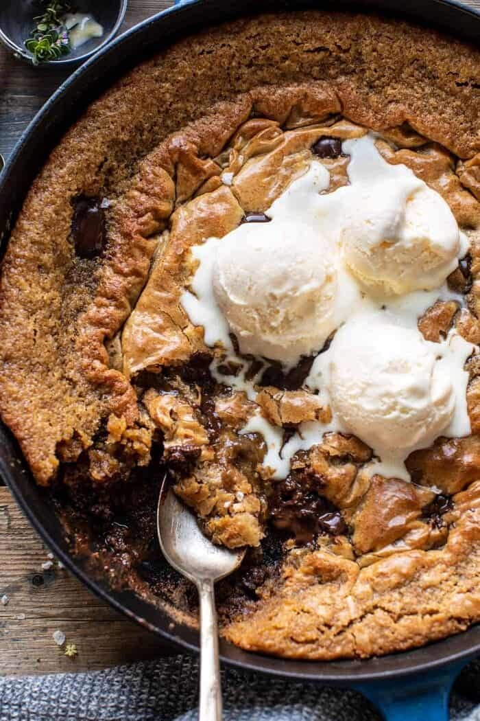 overhead close up photo of Crinkle Top Chocolate Peanut Butter Skillet Blondies with ice cream on top and spoon in skillet 