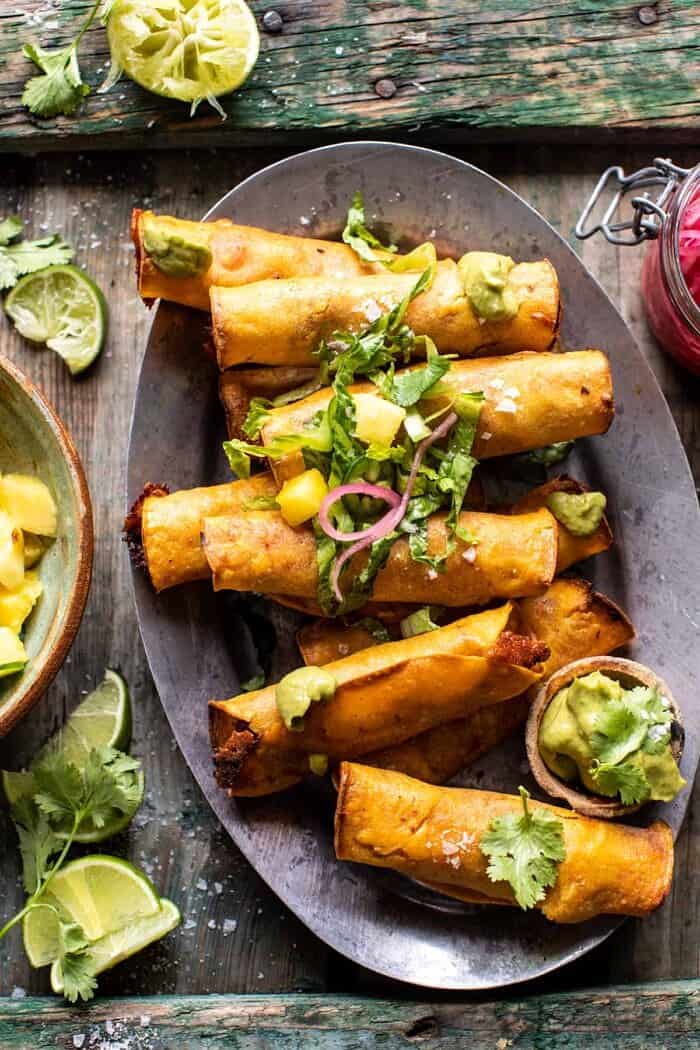 overhead close up photo of Crispy Chicken Tinga Taquitos with Salty Lime Avocado Crema