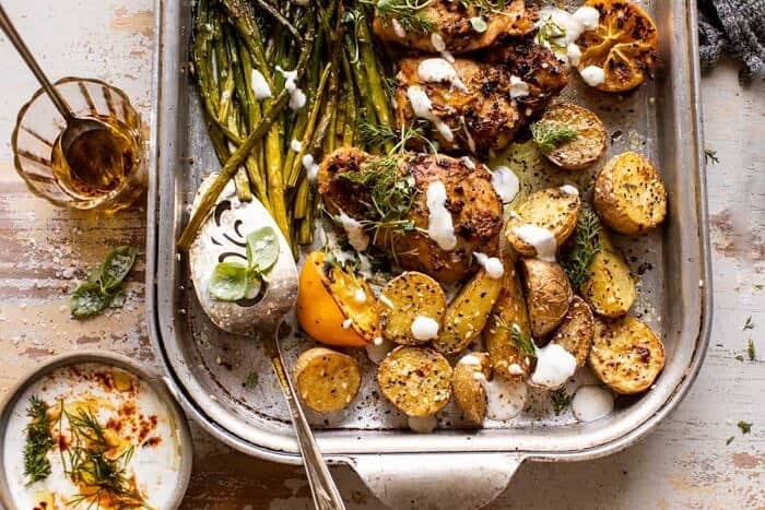 overhead horizontal photo of Sheet Pan Lemon Rosemary Dijon Chicken and Potatoes with Feta Goddess Sauce 
