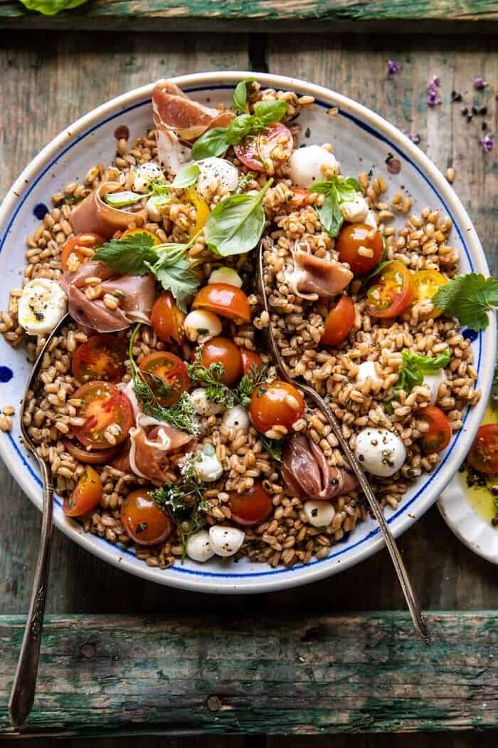 Caprese Prosciutto Farro Salad | halfbakedharvest.com overhead photo of Caprese Prosciutto Farro Salad with spoons in salad bowl