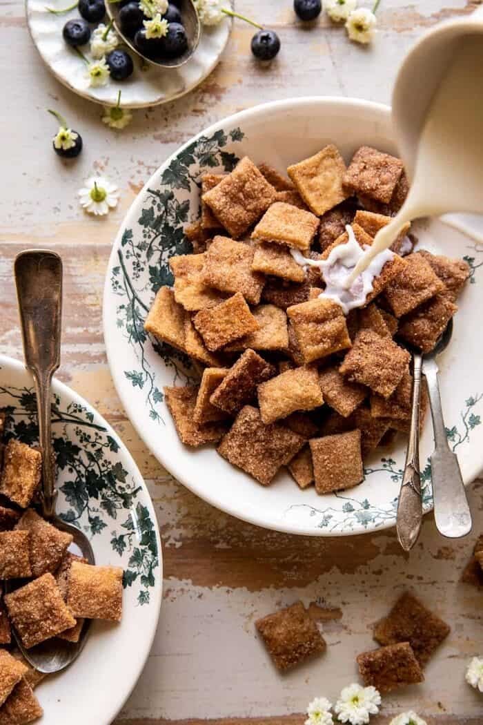 Homemade Cinnamon Toast Crunch | halfbakedharvest.com overhead photo of Homemade Cinnamon Toast Crunch cereal in bowl with milk being poured over cereal