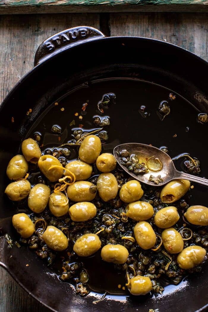 Pan Fried Brie with Peppered Honey and Olives | halfbakedharvest.com overhead photo of olives in skillet
