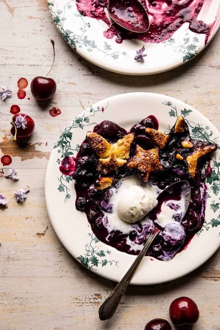 overhead photo of Skillet Blueberry Bourbon Pandowdy on plate with ice cream and spoon 