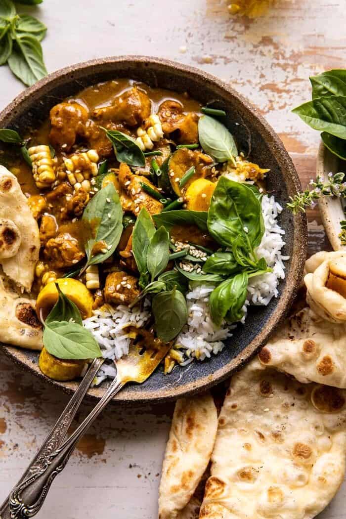 overhead close up photo of Spicy Coconut Basil Chicken Curry with Garden Vegetables with fork in bowl 