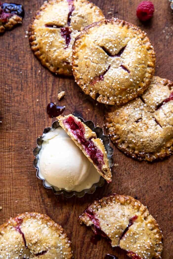 overhead photo of Jammy Raspberry Cream Pretzel Hand Pie broken in half to expose the filling 