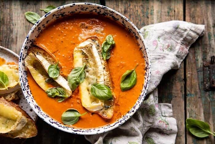overhead horizontal photo of Easiest Herby Tomato Soup with Melted Brie Crostini