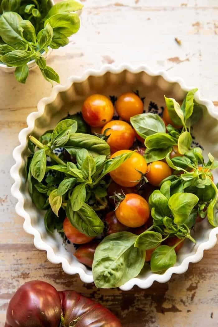 overhead photo of raw tomatoes and basil