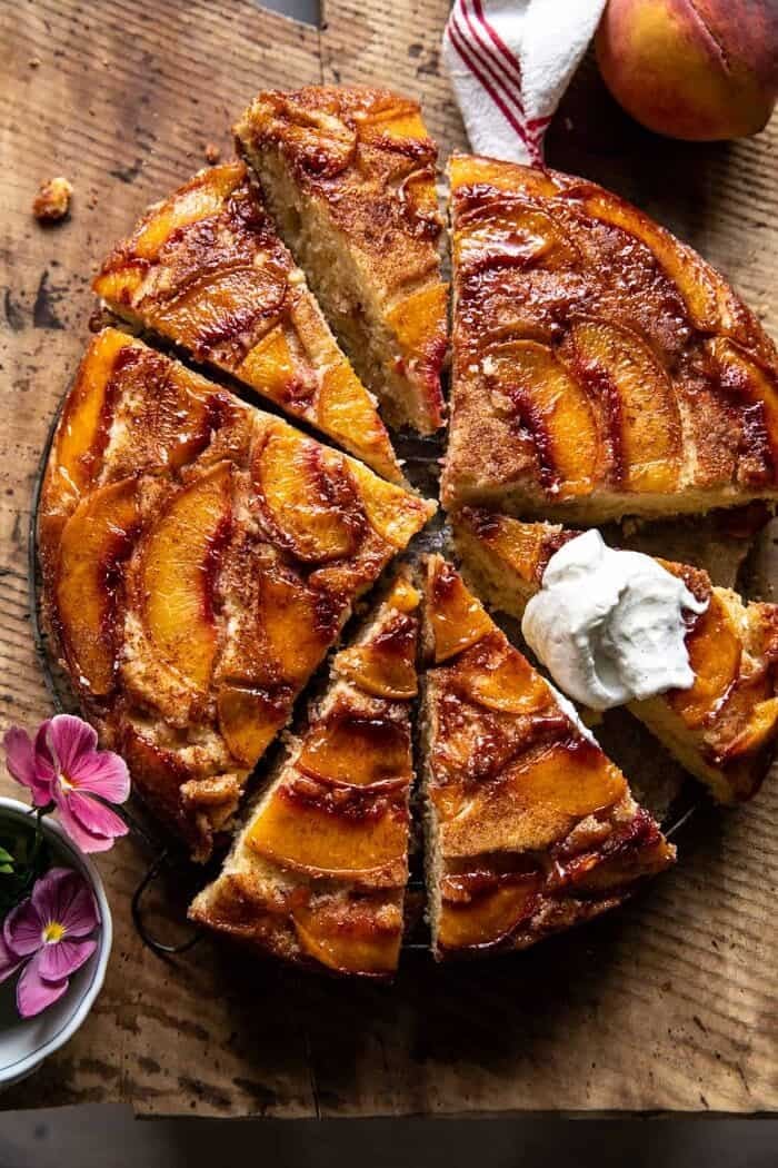 overhead photo of Skillet Cinnamon Sugar Peach Upside Down Cake with whipped cream on top