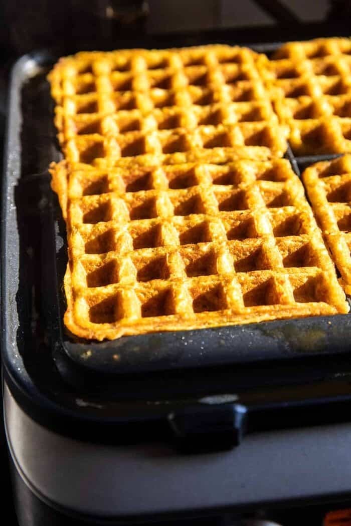 Cider Pumpkin Waffles with Salted Maple Butter | halfbakedharvest.com prep photo of the Cider Pumpkin Waffles cooking in the waffle iron
