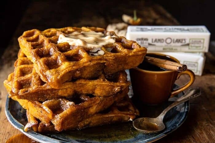 Cider Pumpkin Waffles with Salted Maple Butter | halfbakedharvest.com side angle horizontal photo of Cider Pumpkin Waffles with Salted Maple Butter