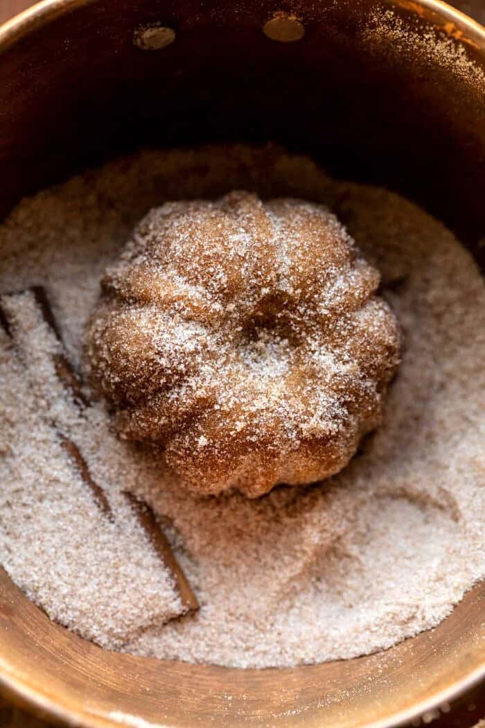 Mini Apple Cider Cakes | halfbakedharvest.com prep photo of Mini Apple Cider Cakes being tossed in cinnamon sugar