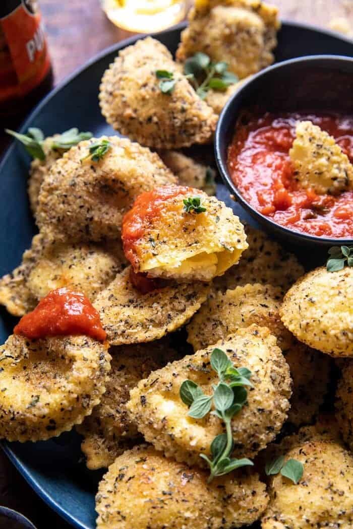 Oven Toasted Garlic Herb Cheese Ravioli | halfbakedharvest.com side angle photo of Oven Toasted Garlic Herb Cheese Ravioli with ravioli broken in half