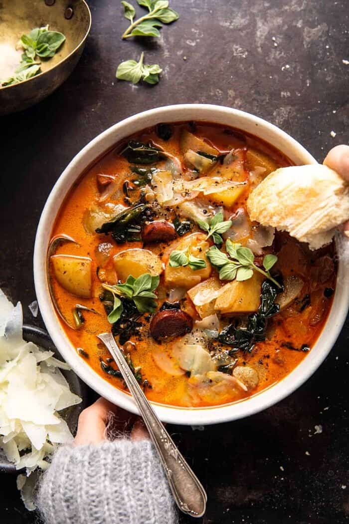overhead photo of Smoky Potato and Kale Soup with hands on bowl 