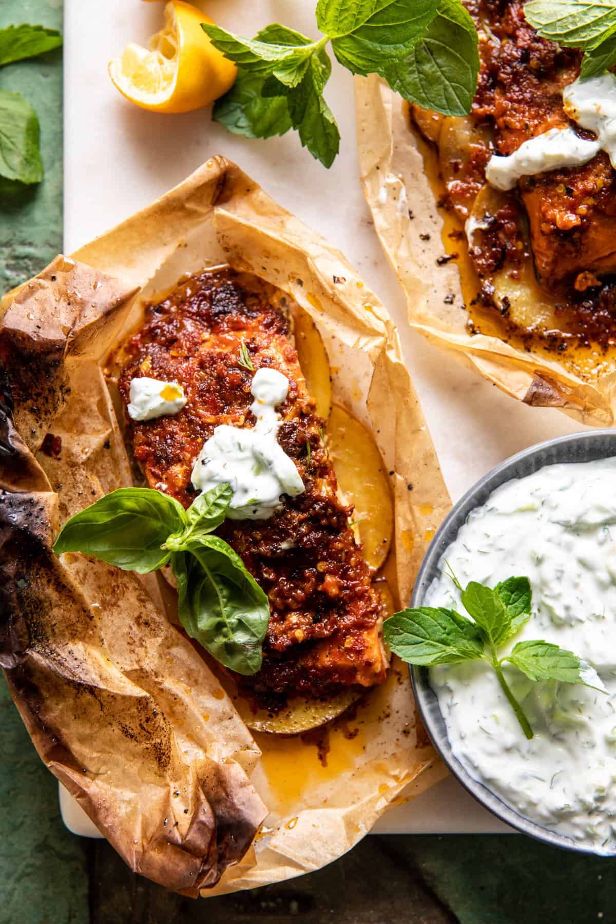 overhead photo of salmon baked in parchment with sauce on the side