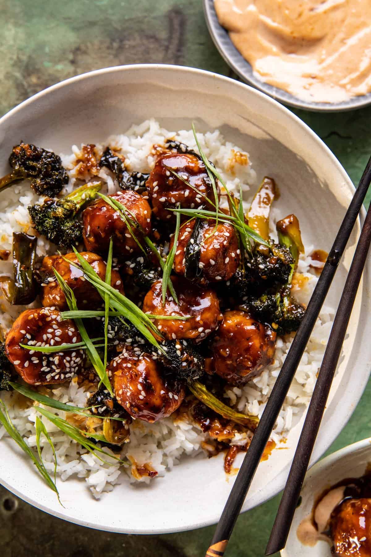 overhead close up photo of meatballs in bowl with rice and chopsticks